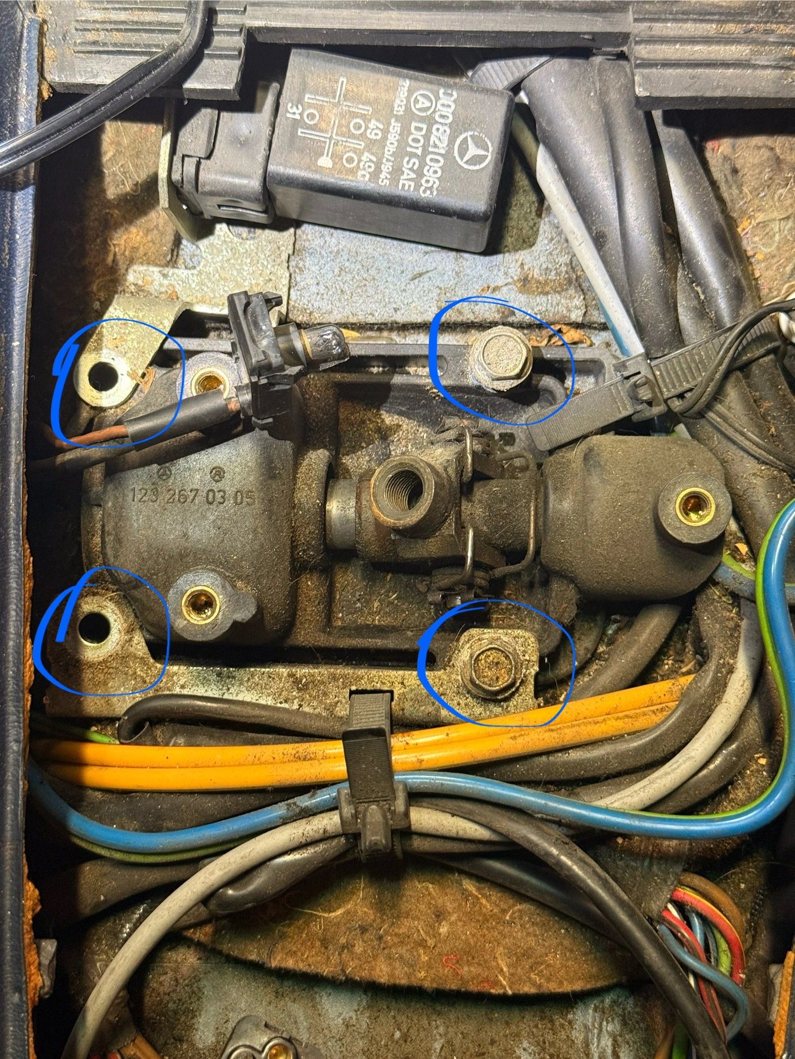 4 through body 10mm hex screws. Also note the ground strap on the top left screw (brown wire).